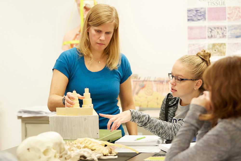Lisa Kobs works with students in an Anatomy and Physiology classroom.