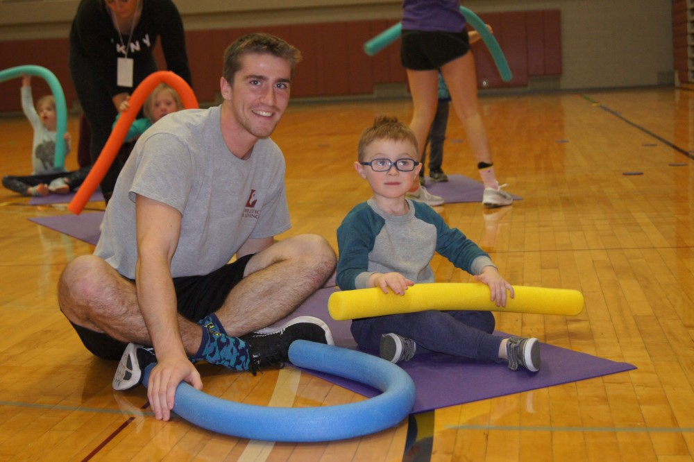 Adapted Physical Education Teaching Minor plays with a child with a disability in the gym.