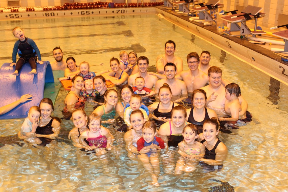 A group of Adapted Physical Education Teaching Minors and children with disabilities pose for a picture in the pool.