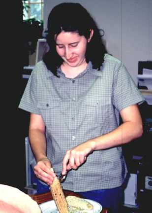 Liz demonstrates removing parched corn kernels from the cob with a spoon. The kernels were then left to dry and put in a jar for future use. Merlin Red Cloud Jr.’s family has used this method for generations.