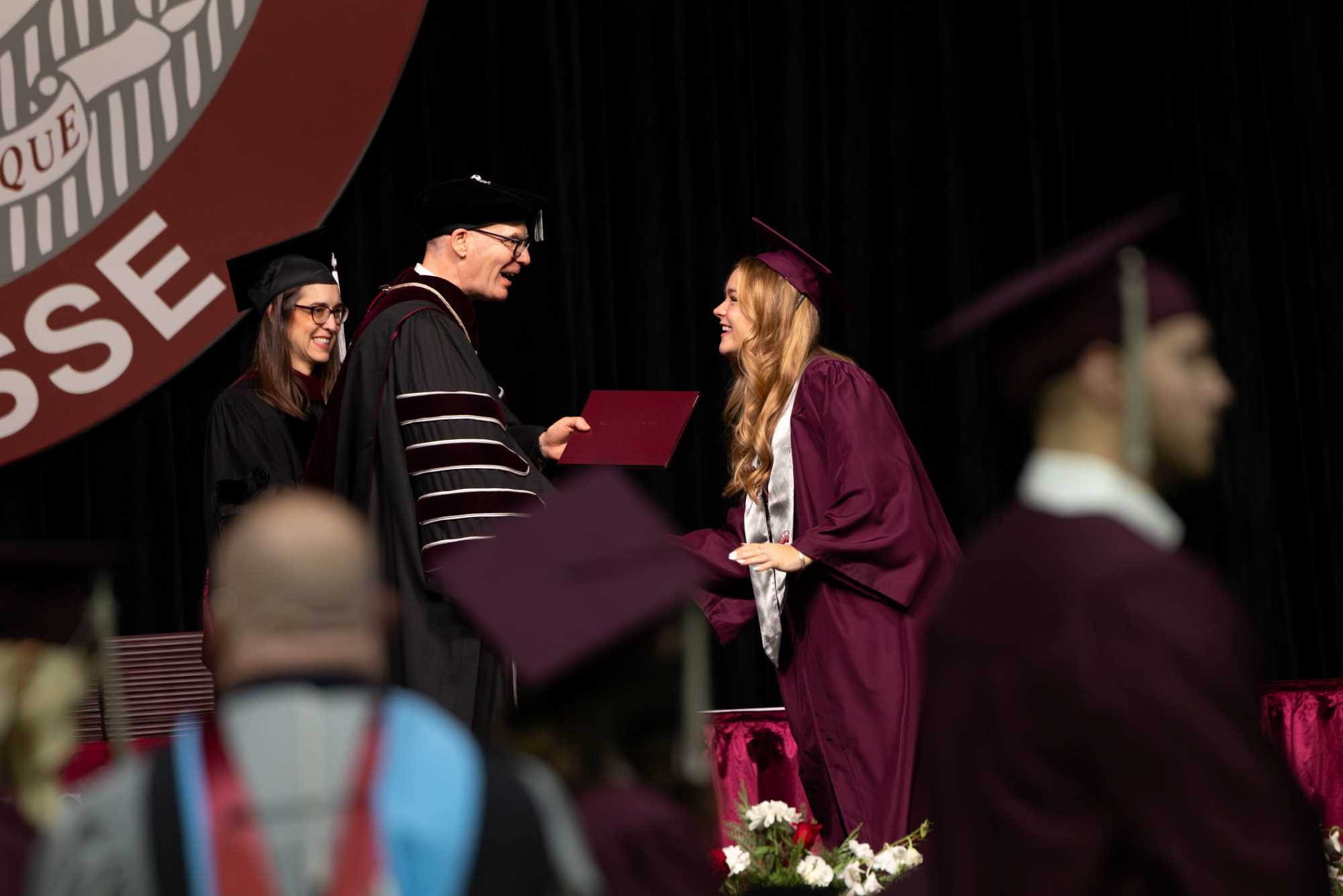 Chancellor Beeby handing a student their diploma during the Winter '24 Commencement