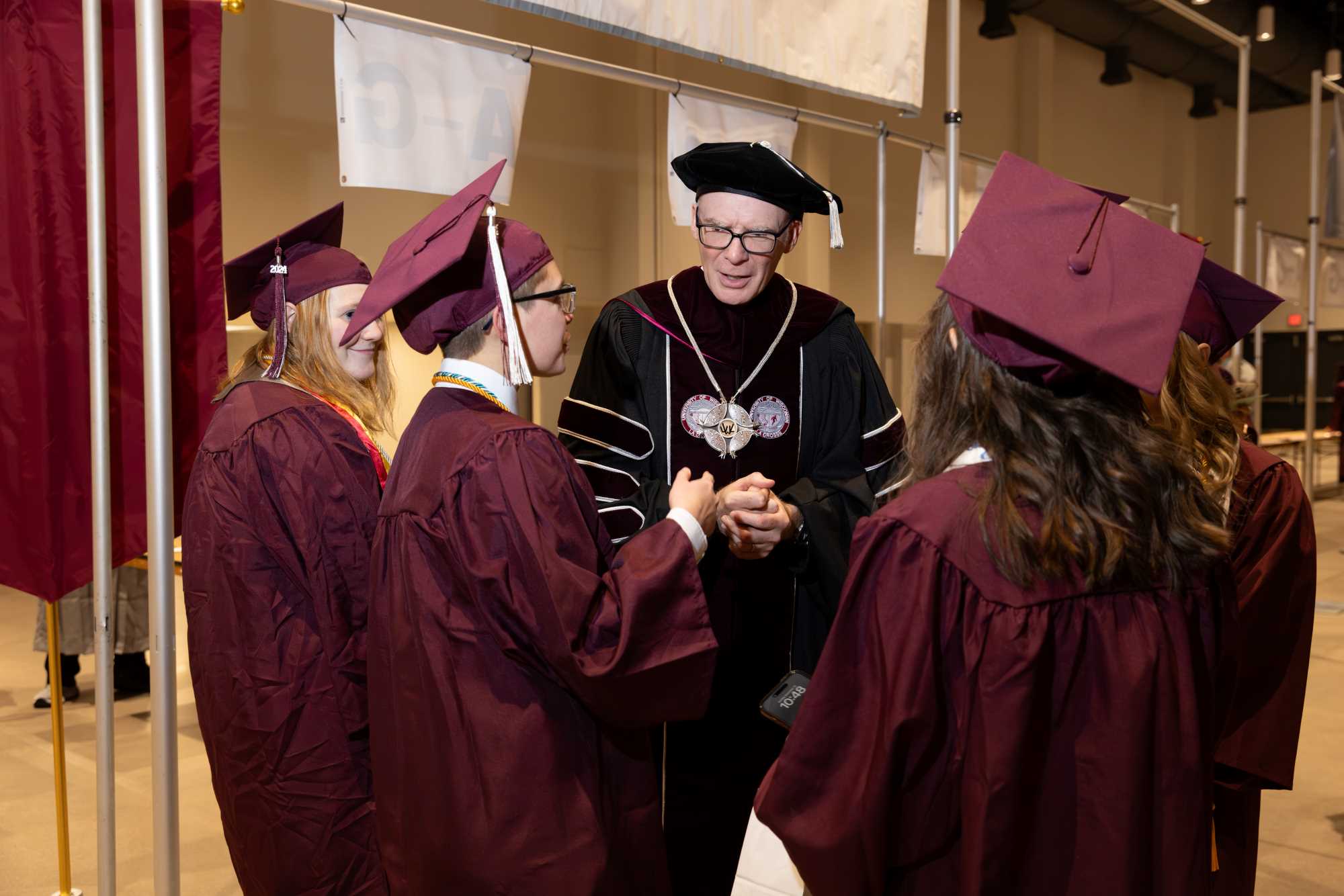 Chancellor Beeby talking with students before the Winter '24 Commencement begins